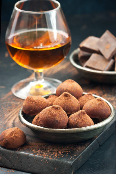 Whiskey or brandy, truffle chocolate candies in cocoa powder and dark chocolate