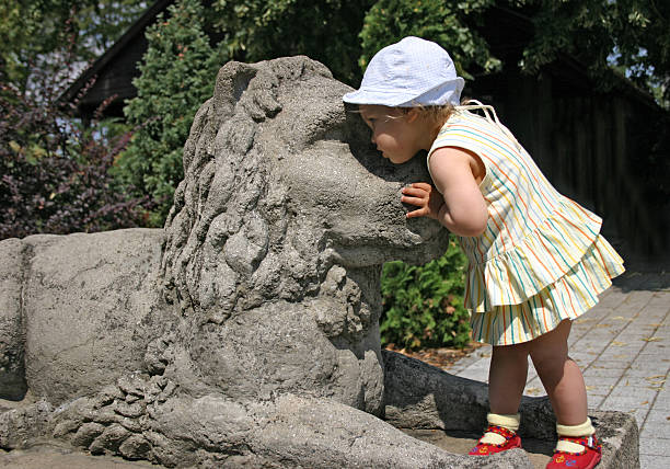 Little girl and stone lion - monument