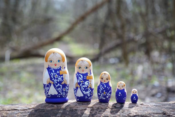 Photo of nesting dolls in the forest. Painted toys