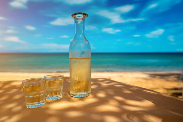 Bottle of white wine with glasses on a table by the sea